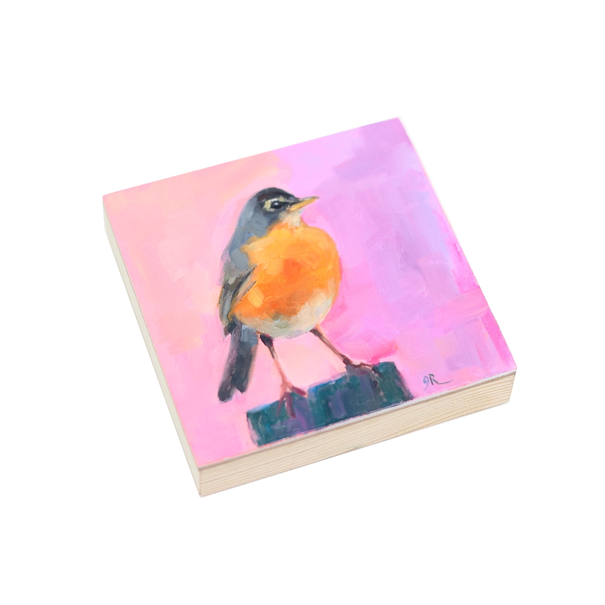 Oil painting on a 4x4” panel  by Jessica Richter, depicting a vibrant American robin perched on a dark post. The bird has a bright orange chest, grayish-black wings, and a sharp beak, with expressive brushstrokes adding texture. The background features a soft blend of pink and purple hues, creating a warm, dreamy atmosphere. The artist’s initials “JR” are subtly signed in the bottom right corner.