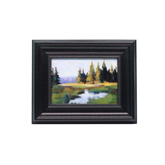 Framed painting of a landscape with trees and a pond on a white background